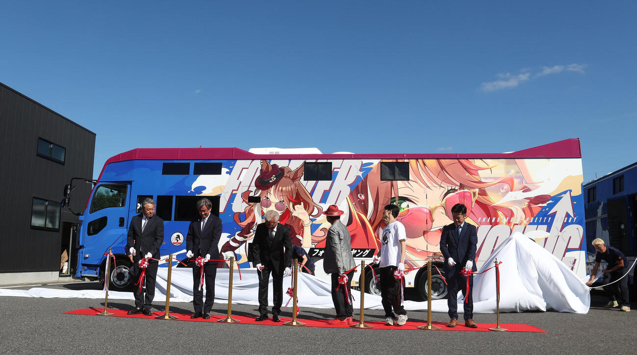テープカットの後にお披露目されるウマ娘のフォーエバーヤンがグラッピングされた馬運車（撮影・白石智彦）