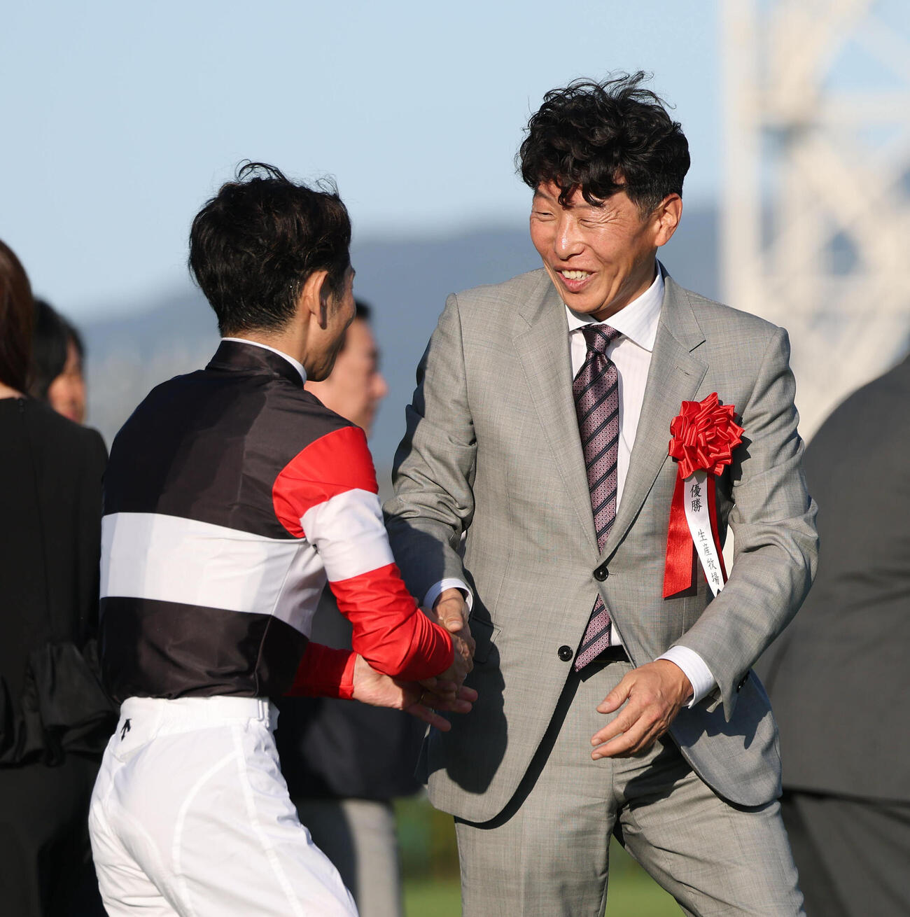 握手する戸崎圭太騎手（左）と吉田俊介ノーザンF副代表（撮影・白石智彦）