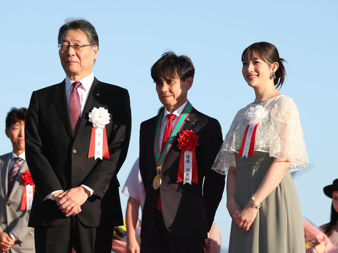 記念写真に納まる、左から吉田正義JRA理事長、上村洋行調教師、プレゼンターの足立梨花