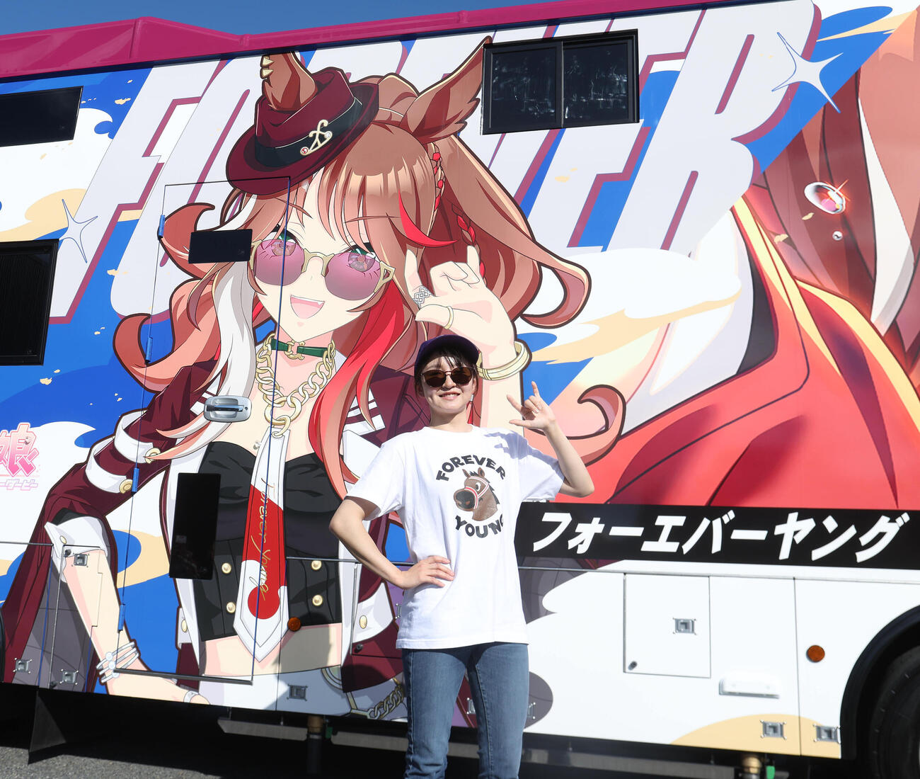 ウマ娘のフォーエバーヤンがグラッピングされた馬運車を背に同じポーズする古川奈穂騎手（2026年10月15日撮影）