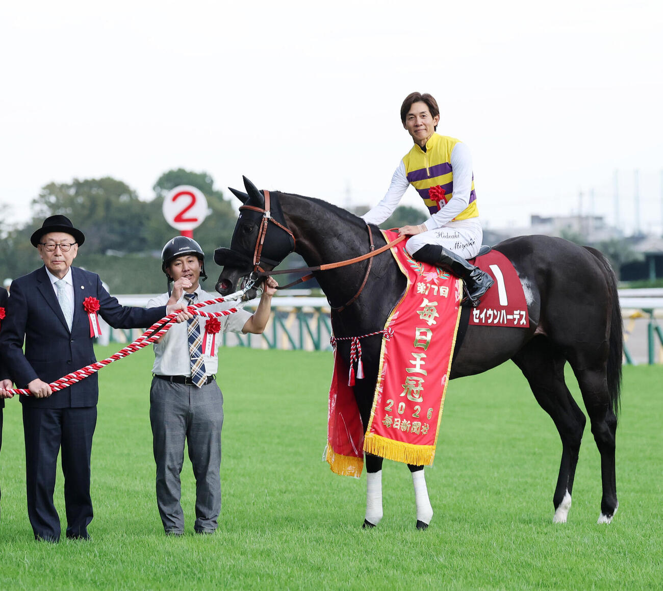 毎日王冠をセイウンハーデスで口取りに臨む西山茂行オーナー（左）