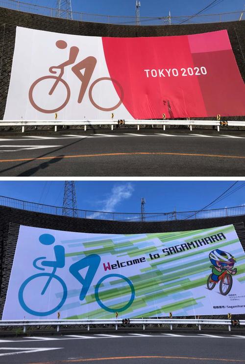 上は五輪時に掲出されていた巨大ピクトグラムの横断幕。下は今年7月25日に設置された横断幕