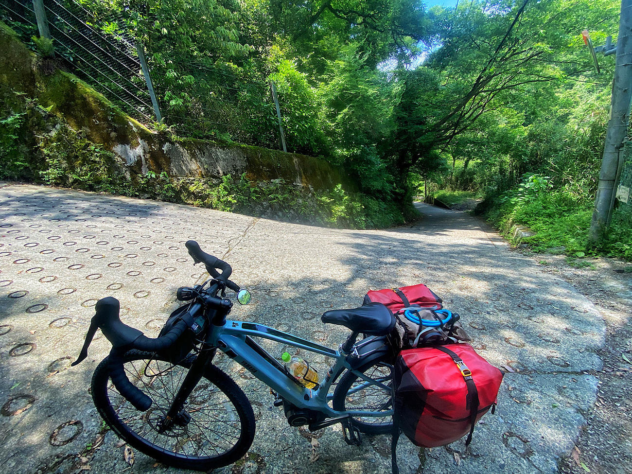 傾斜の緩やかなところにE-Bikeを止めて息を整える