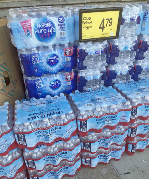 スーパーマーケットの店舗前に山積みで売られている大量のペットボトル飲料水