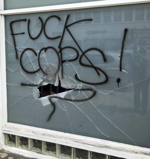 警察官なんてくそくらえの文字と割られたガラス