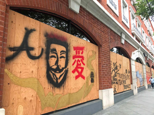 暴動に備えて店の窓ガラスを覆う防護板に漢字で「愛」と書かれたメッセージも