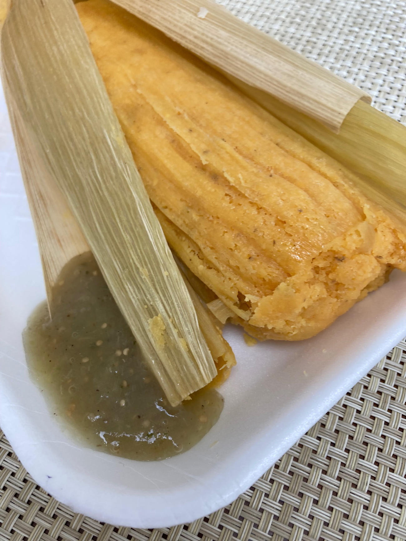 グリーントマトを使ったソースをかけて食べるタマレ