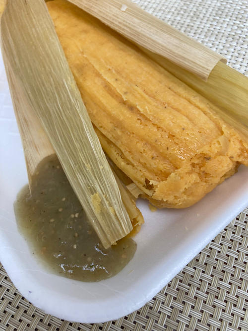 グリーントマトを使ったソースをかけて食べるタマレ