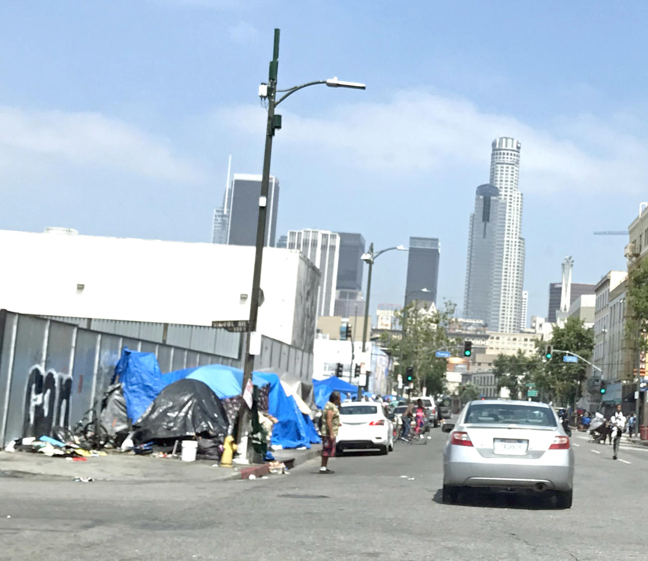 スキッド・ロウの歩道はテントで占拠され、車が往来する歩道をうろつく人も