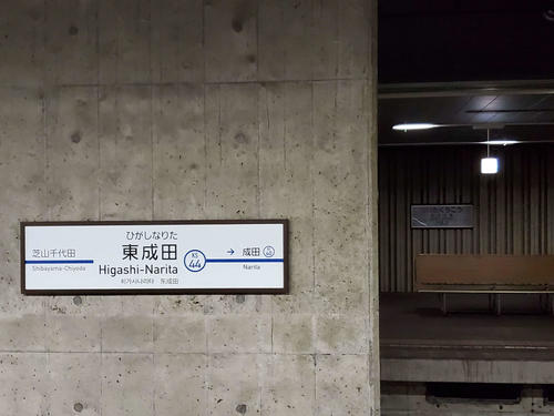 〈13〉東成田の駅名標。奥の使用されていないホームには成田空港の駅名標が残っている