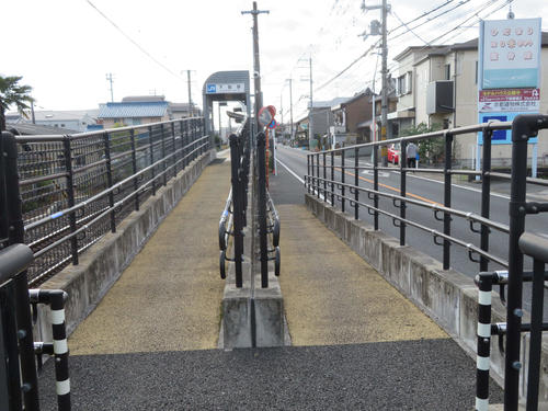 〈7〉下狛駅は狭いスペースに設置されているため歩道が2つに割れて入る構造となっている