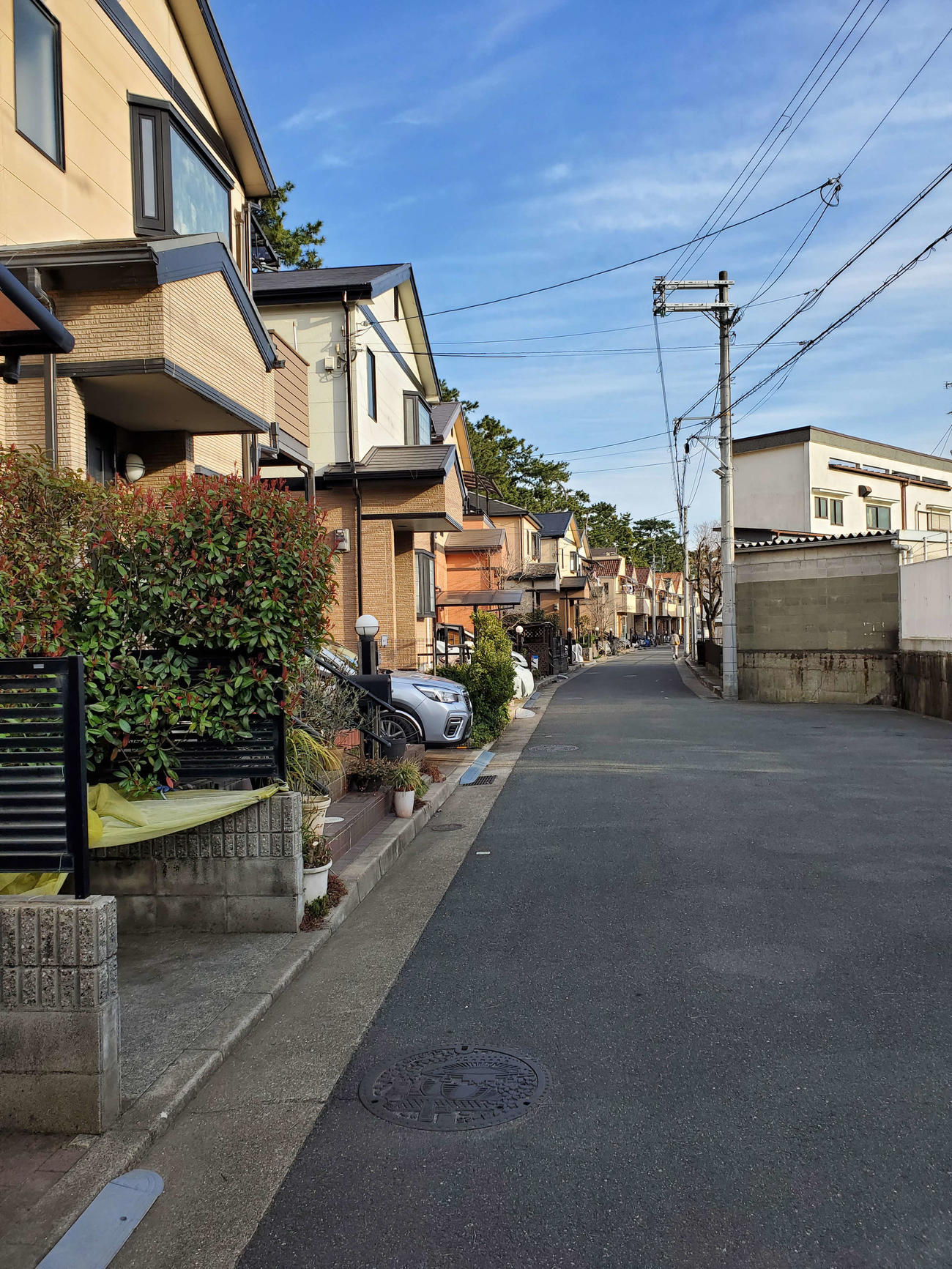 〈11〉カーブに沿うように住宅が並んでいる。道路の右側は古い建物が多い