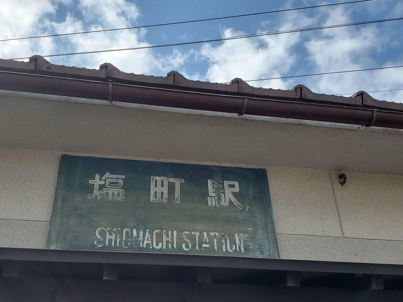 （2）年季の入った駅名板が駅舎に掲げられている