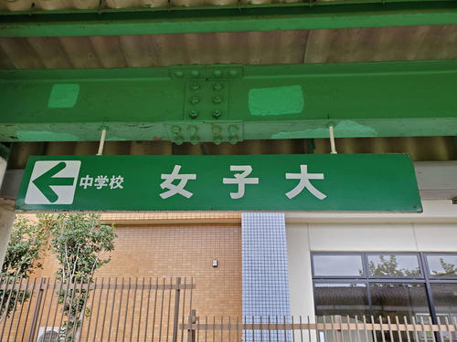 〈4〉女子大の駅名標。「女子大」と「中学校」が並ぶ