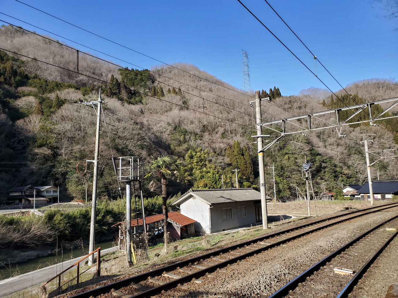 〈3〉駅の目の前は川。家が数軒あるだけで山に囲まれている