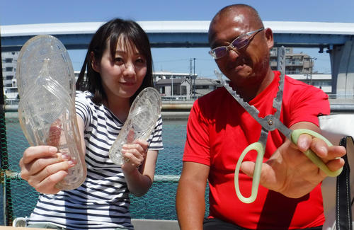魚つかみを手にする日刊スポーツ釣り担当タコボウズ寺沢（右）と「ギョサン」を手にする釣り初心者の矢島（撮影・鹿野芳博）