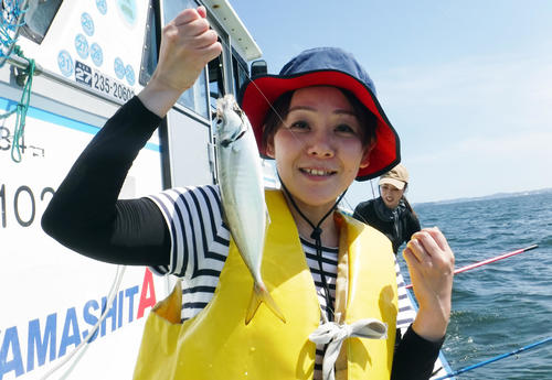 アジを釣り上げ笑顔を見せる日刊スポーツ釣り初心者の矢島（撮影・鹿野芳博）