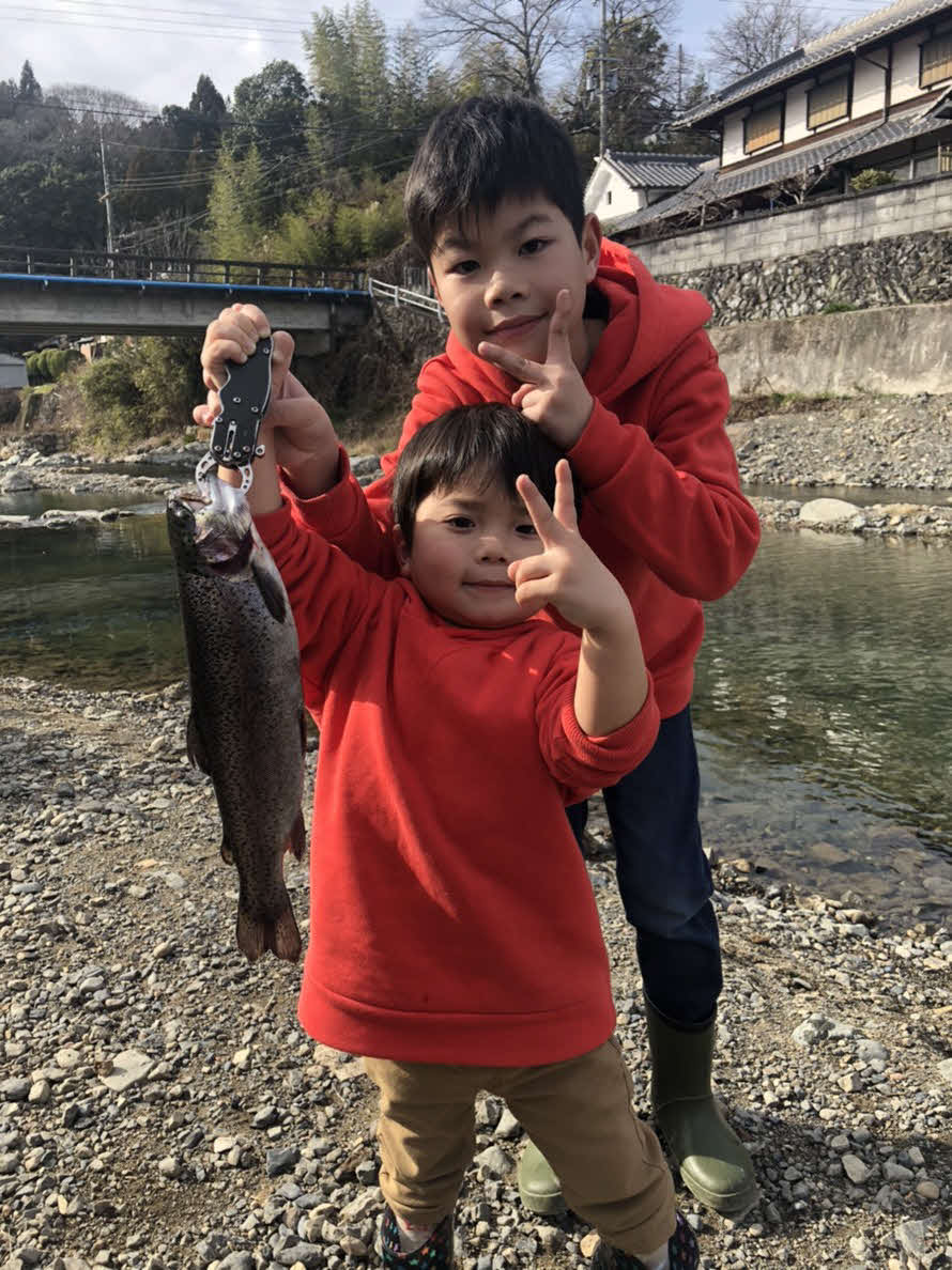 2人でゲットした38センチのマスをうれしそうに持ち上げる琉央君（後方）と朝耀君