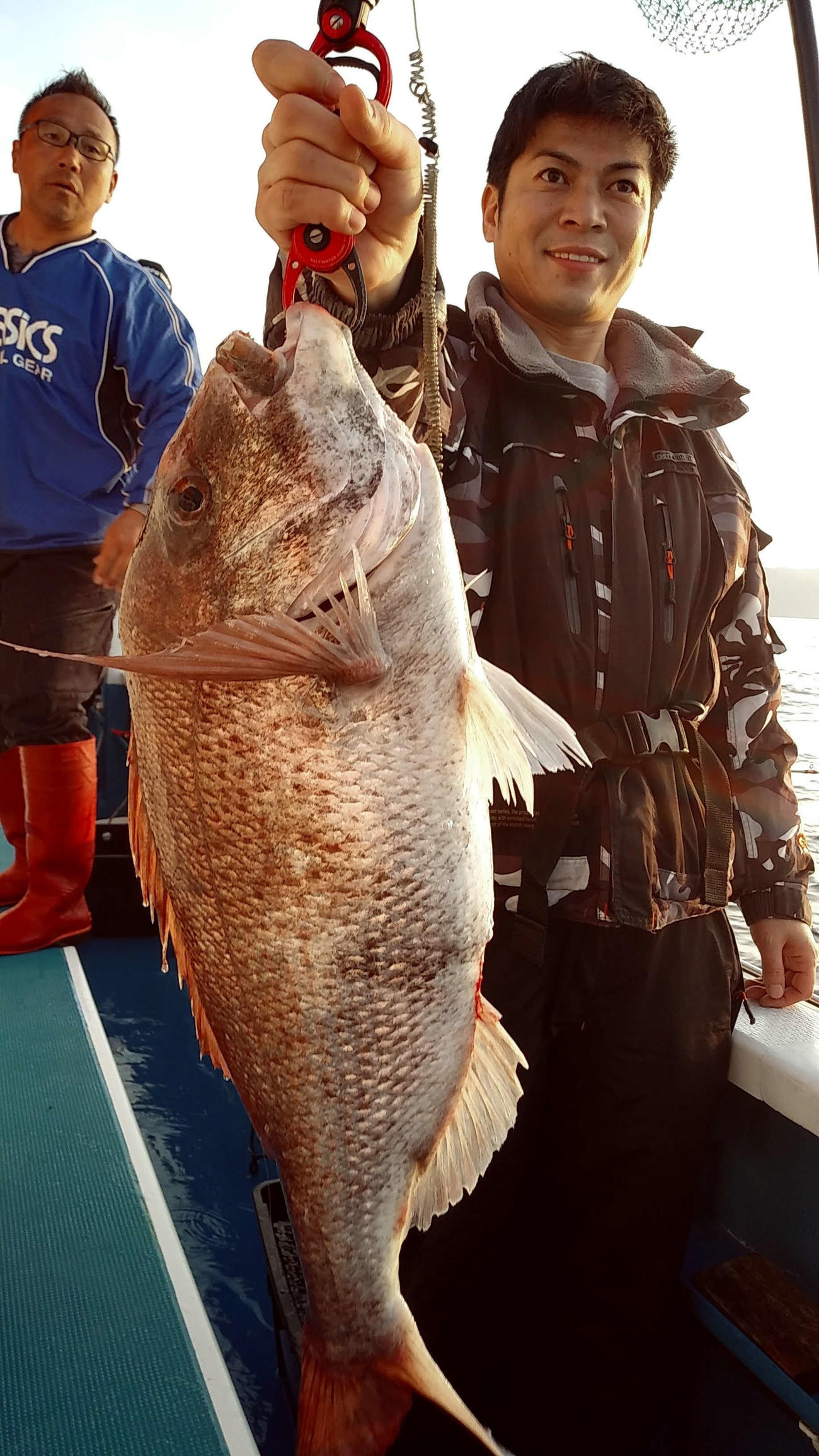 白田さんは、釣り上げた4・9キロをグイ、と前に突きだした