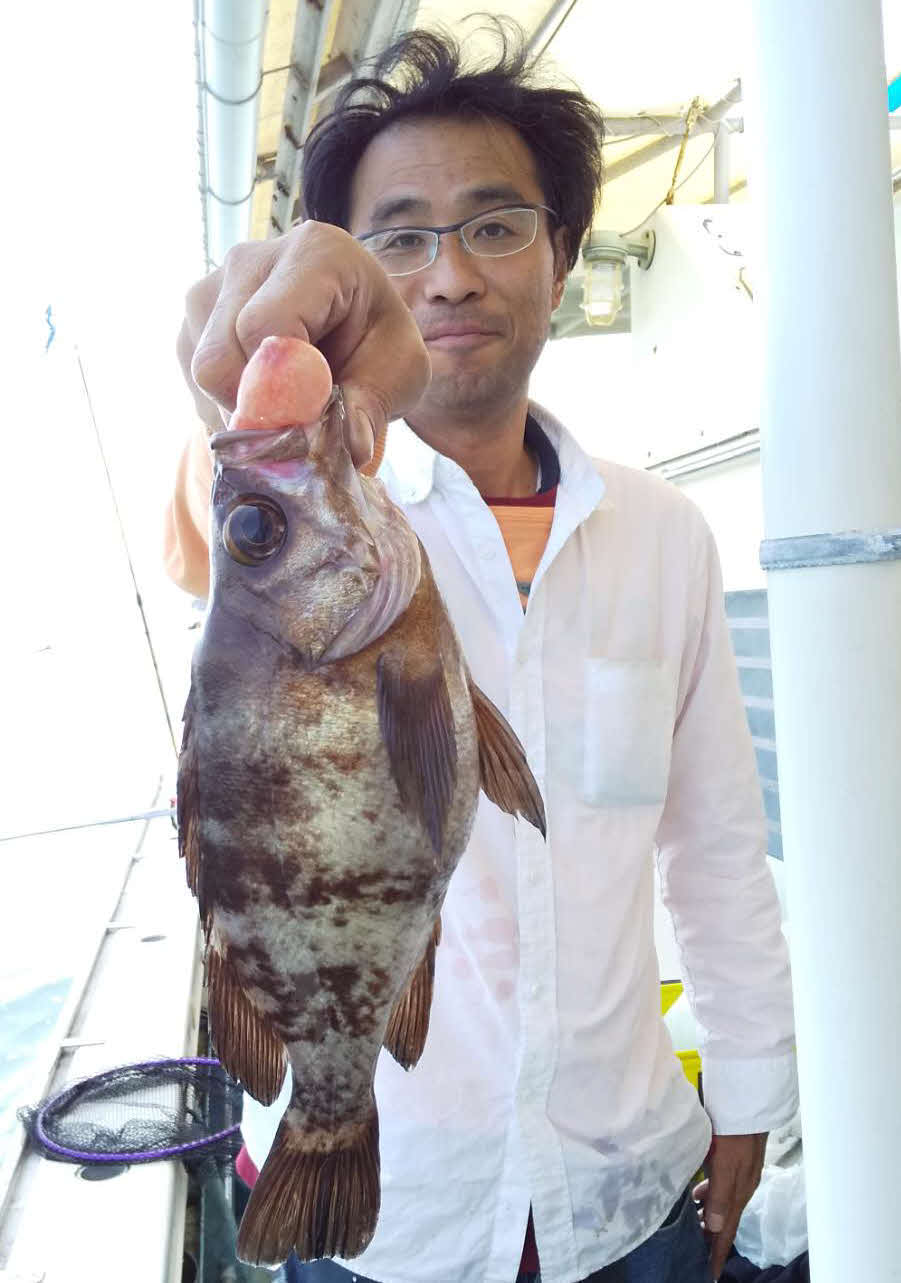 苦戦の末に仕留めた大型のクロメバルを披露する高橋さん