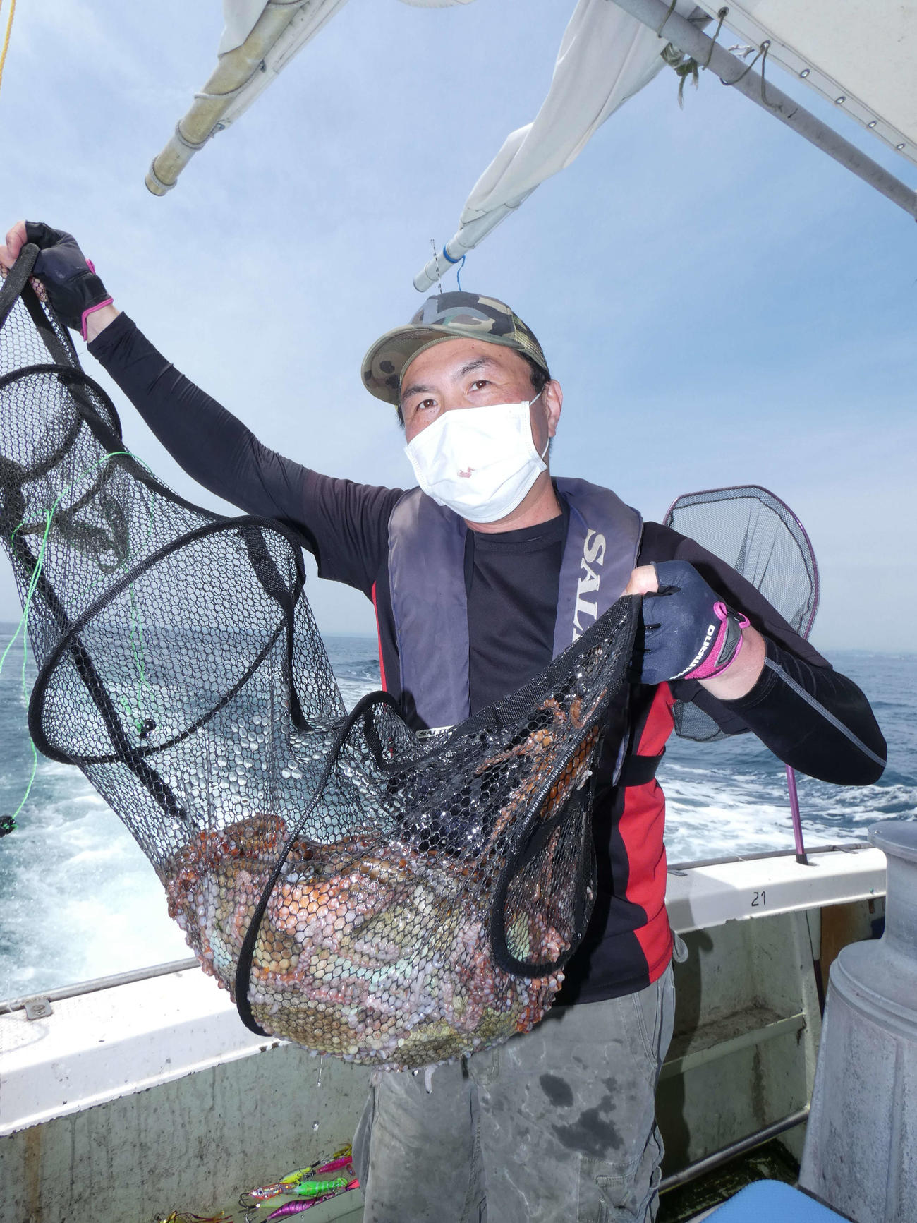 釣ったマダコを披露する宮崎さん