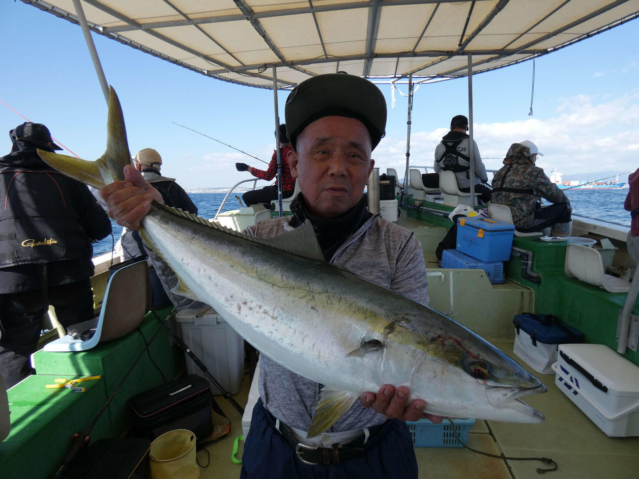 タチウオテンヤで仕留めた100センチのブリを披露する小池さん