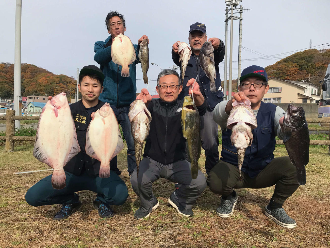釣果のカジカ、アブラコ、クロガシラを掲げる北海道遊釣倶楽部の、前列左から大杉和洋さん、武市毅さん、大野昭彦さん、後列左から太田良弘さん、佃克俊さん