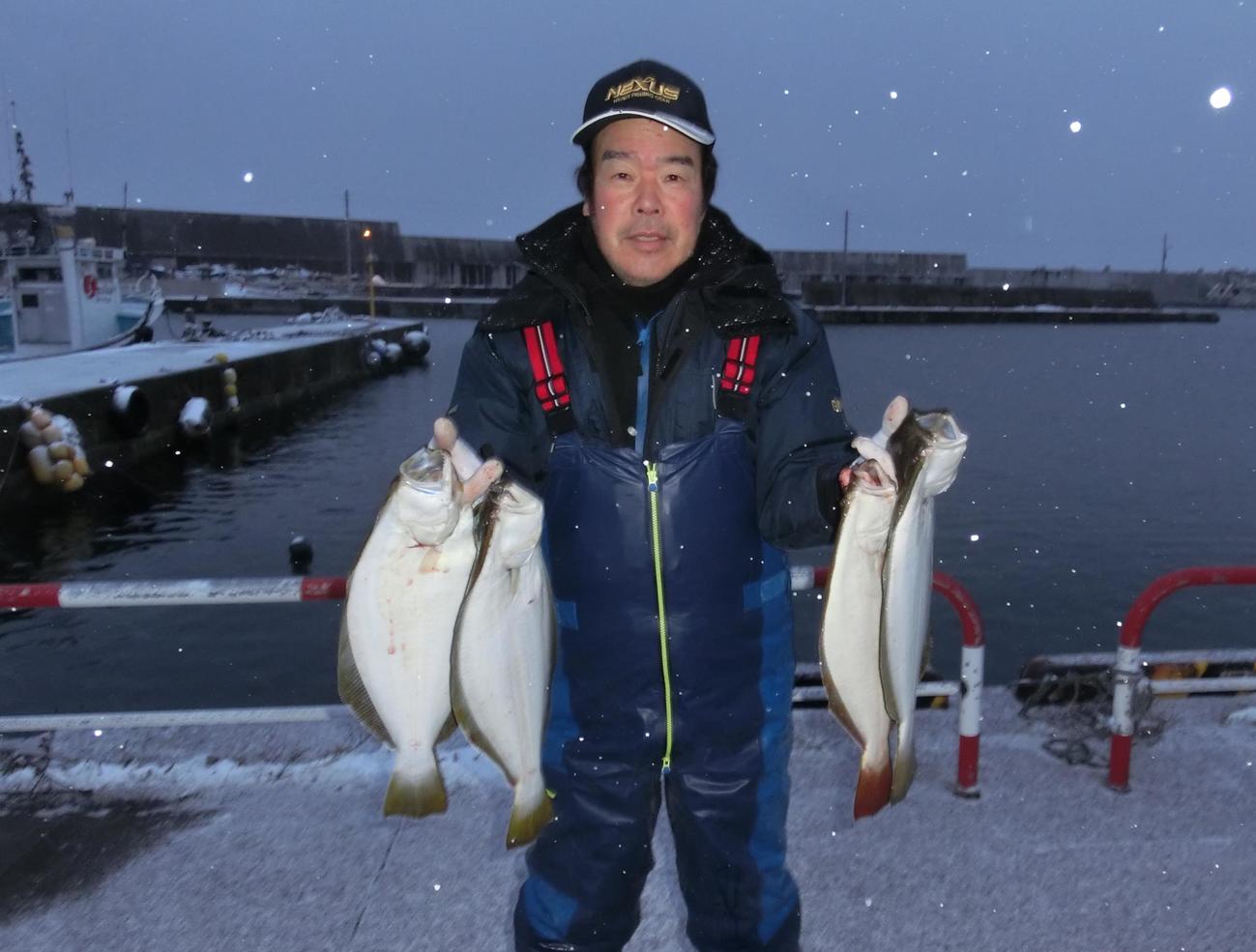 美国漁港でヒラメを手にするリポーターの竹鼻さん