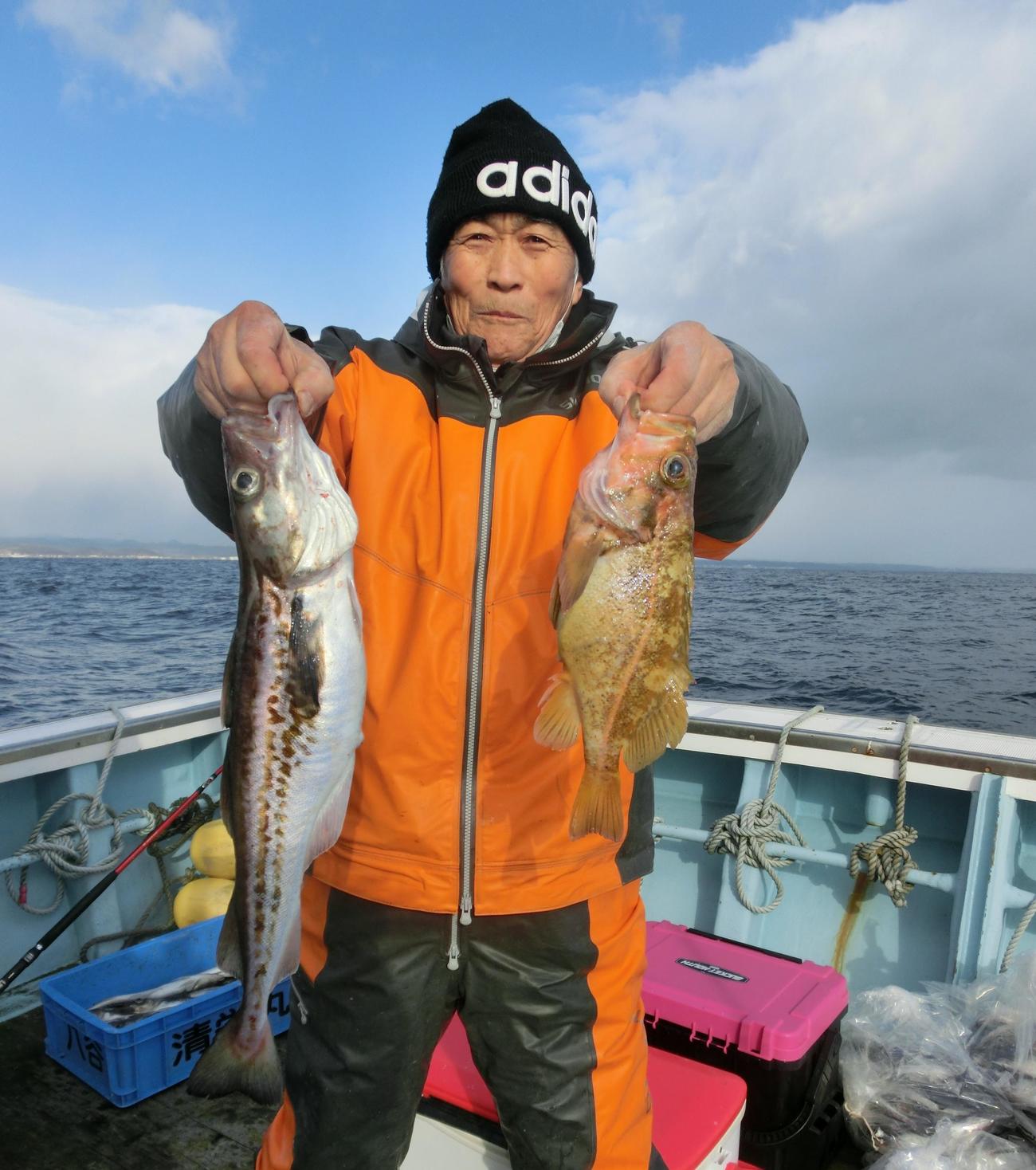 清栄丸でスケトウダラ（左）などを手にする札幌市の久保さん