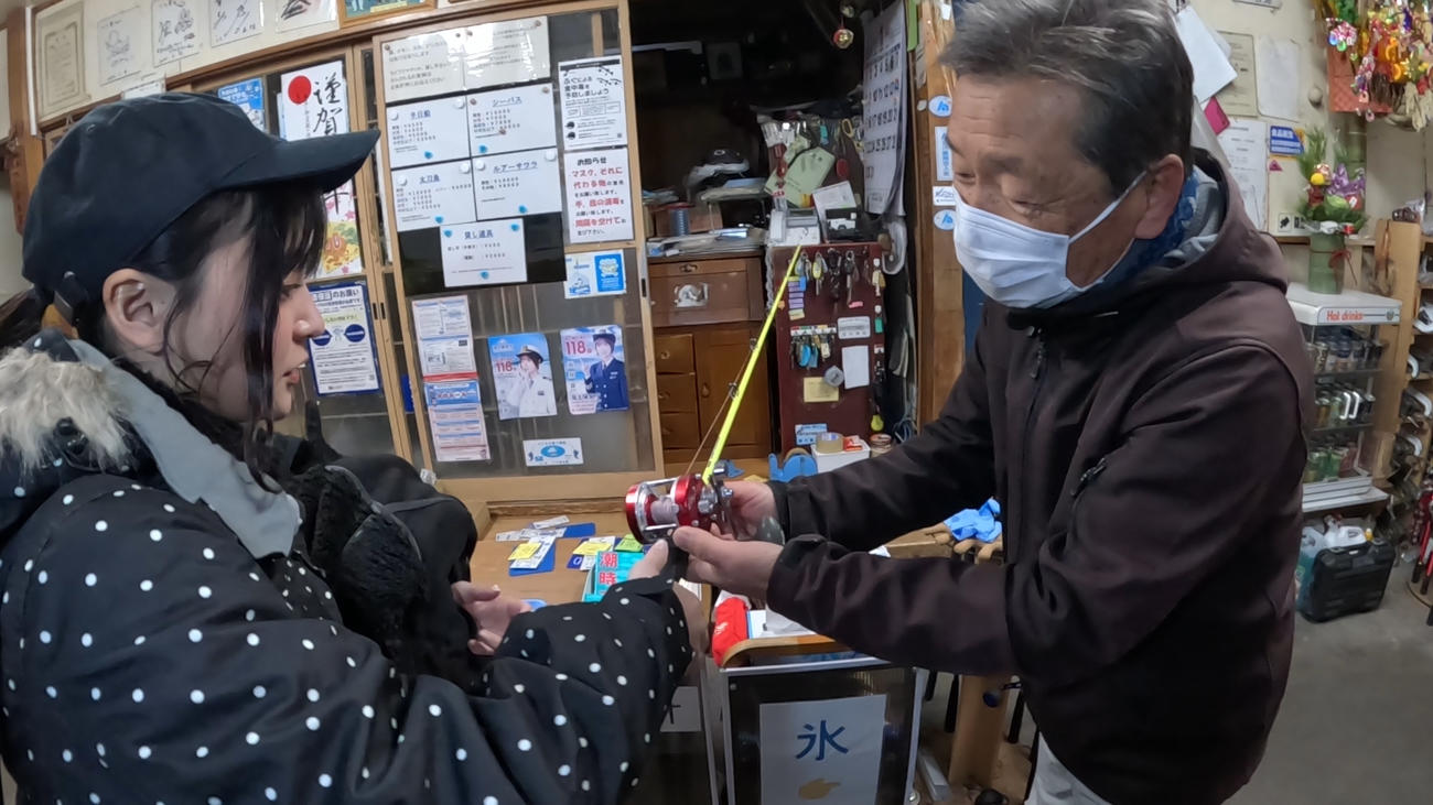 幸田一夫代表（右）からリールの使い方を教わる