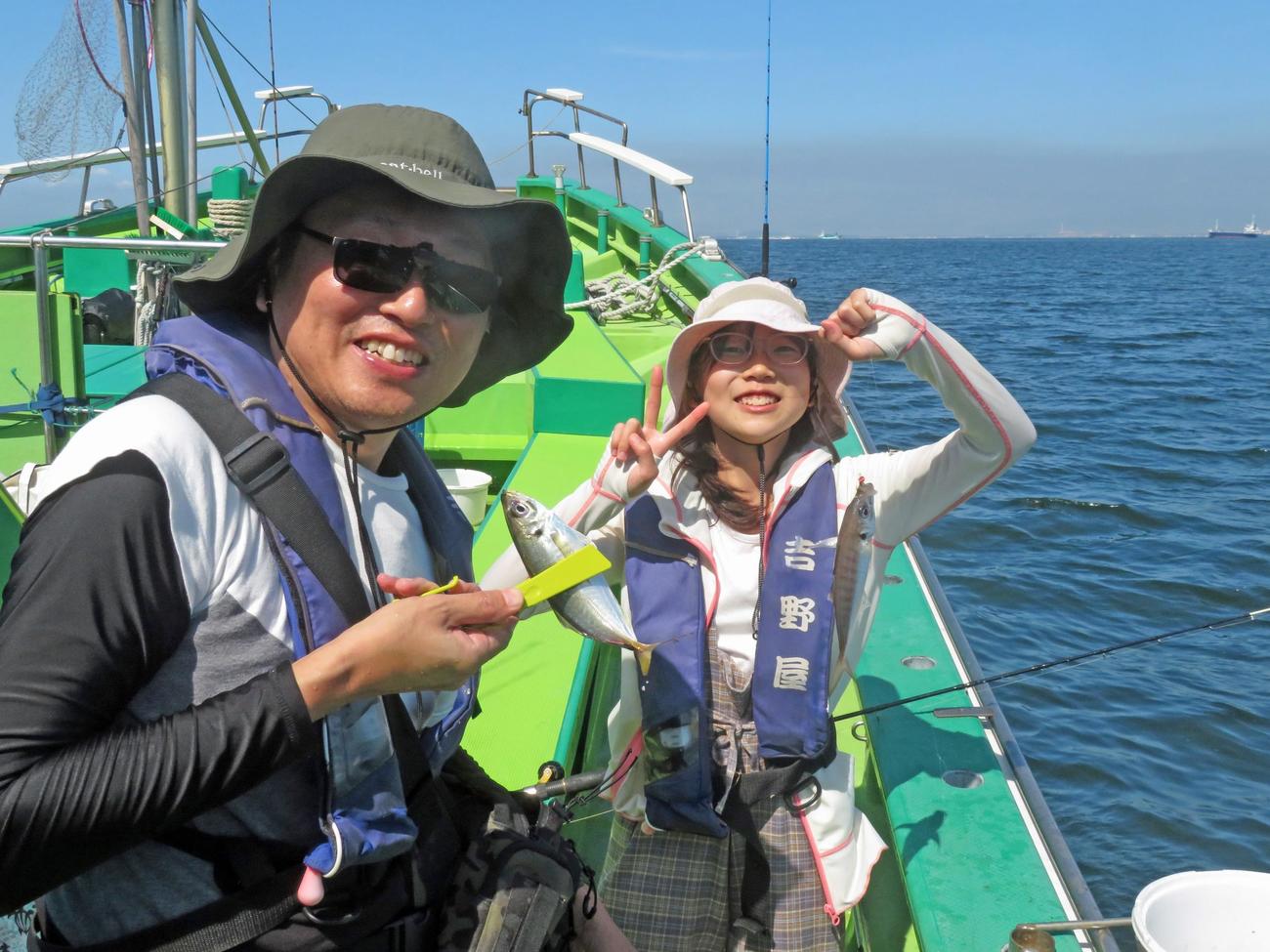 親子でアジをゲットし披露する高野淳さん（左）とピースサインの優衣さん