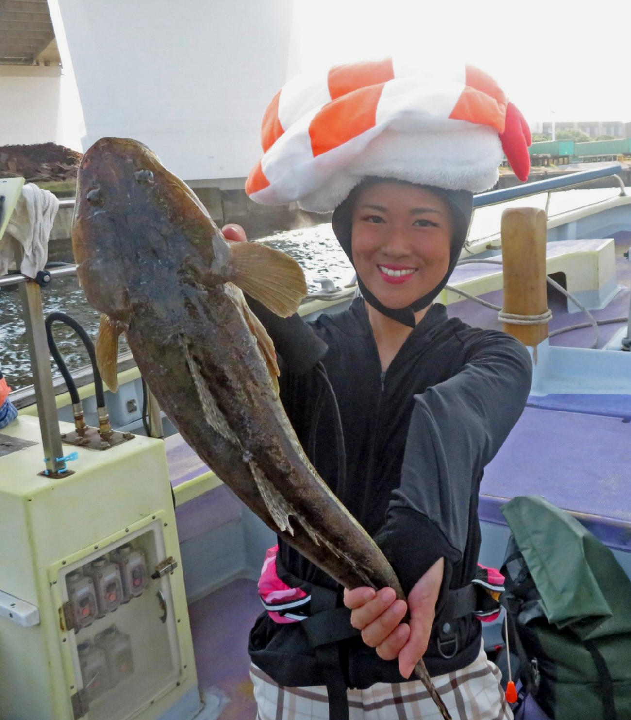 エビネタおすしのかぶりモノも本人は大真面目！　53センチを釣り上げ笑顔の出光仁美