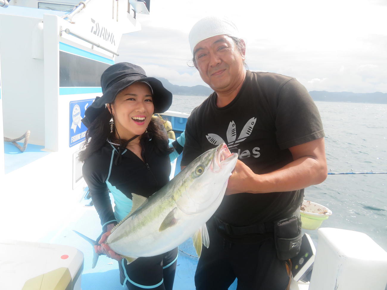 6・82キロワラサを釣り上げた釣り友の木村孝一郎さん（右）を祝福する出光仁美