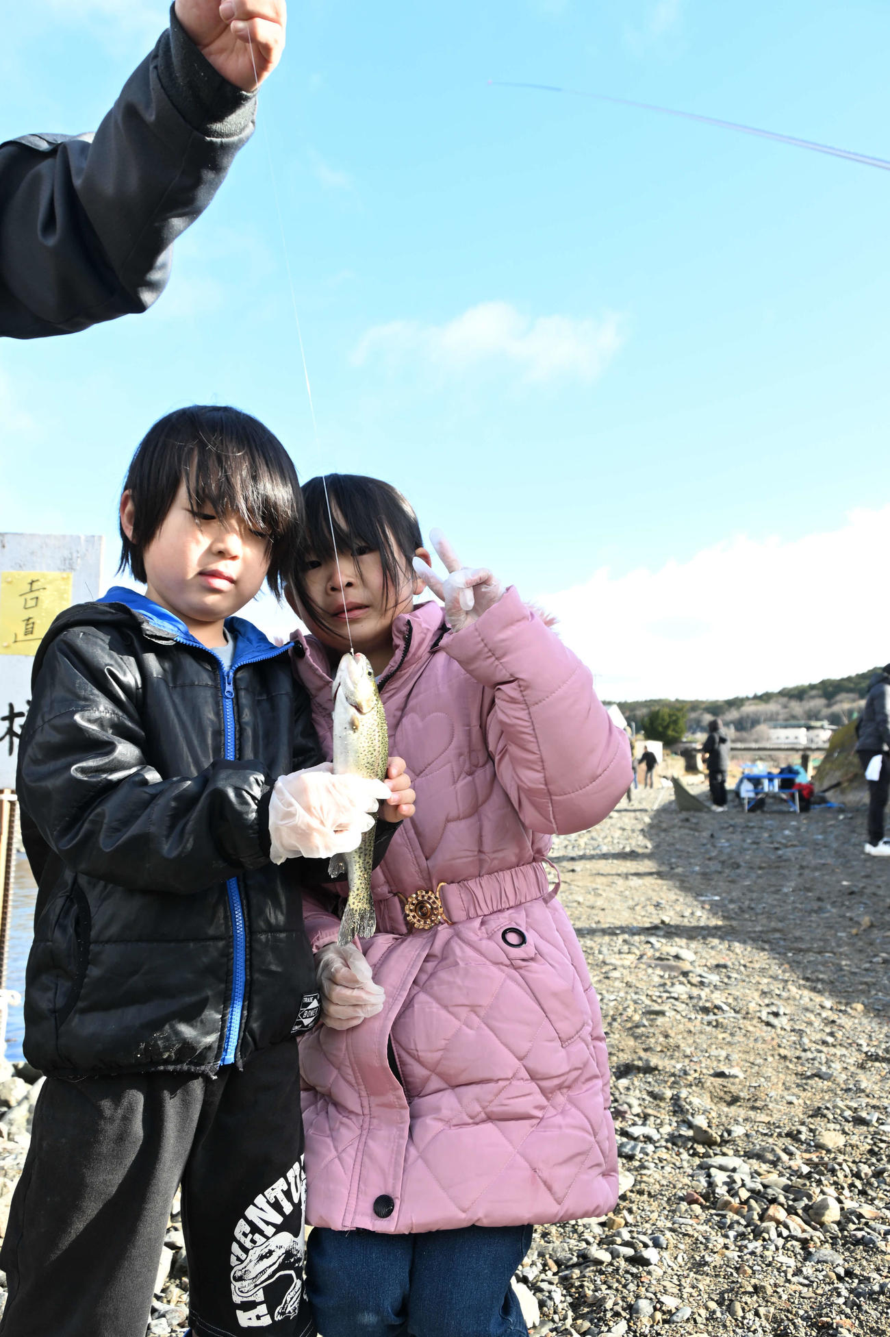 ニジマスを披露する吉直結乃ちゃん（右）と結弦君