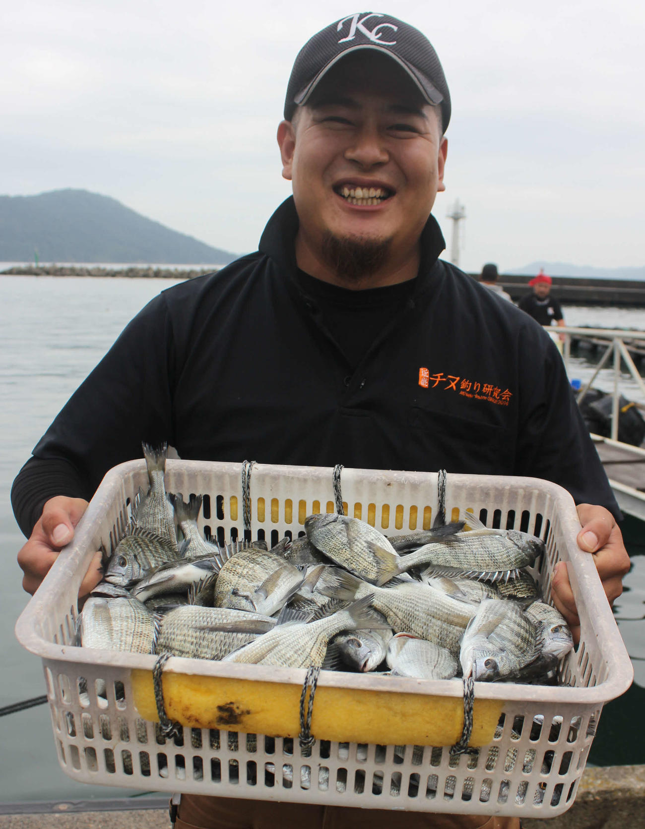 釣り上げたチヌ（15～30センチ、77匹）を披露する谷さん