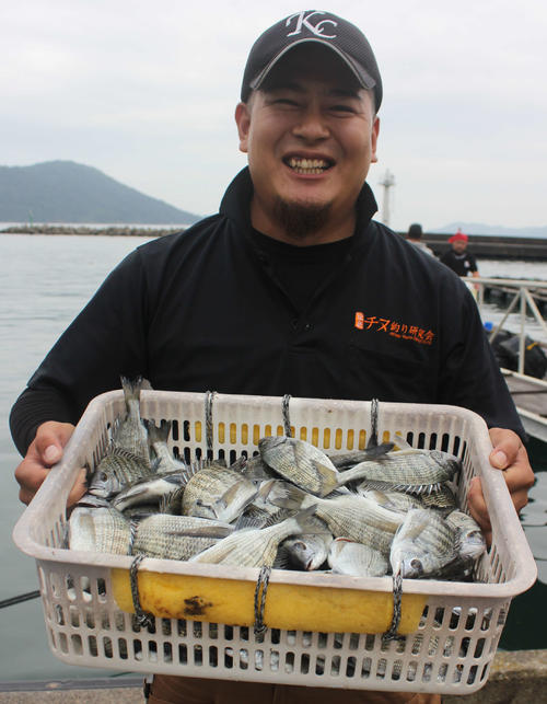 釣り上げたチヌ(15~30センチ、77匹)を披露する谷さん