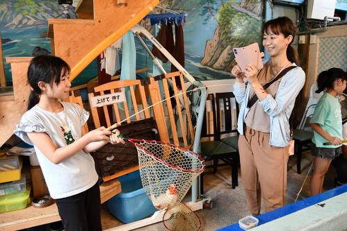 コイが釣れて思わずニッコリ。ママは撮影役