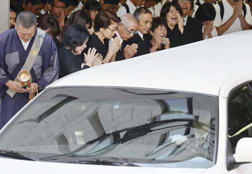 葬儀会場を出る松尾愛和さんのひつぎを乗せた車を、泣きながら見送る参列者（共同）