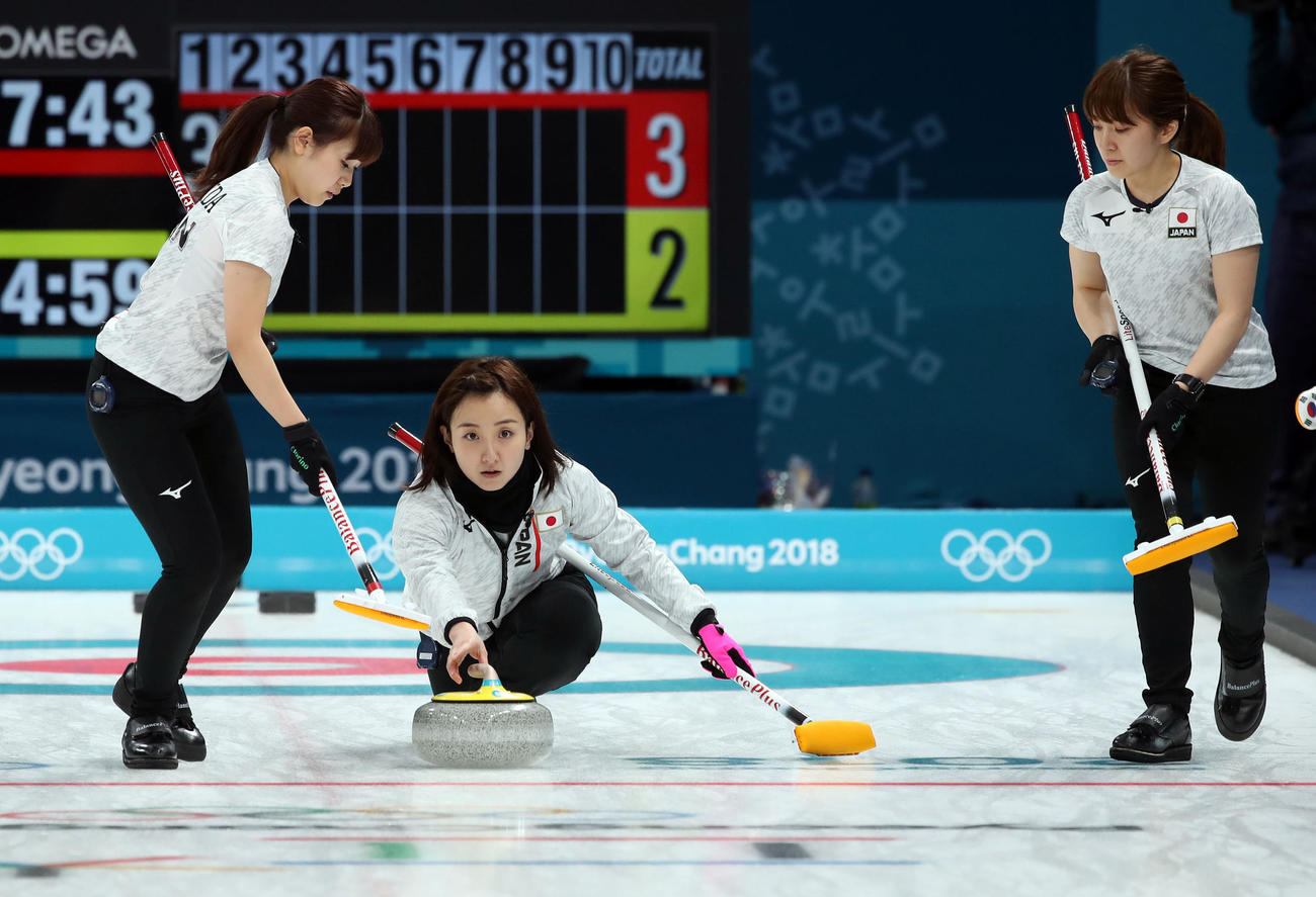 準決勝　日本対韓国　ショットを放つ日本スキップ藤沢。左はリード吉田夕、右はセカンド鈴木＝2018年2月23日