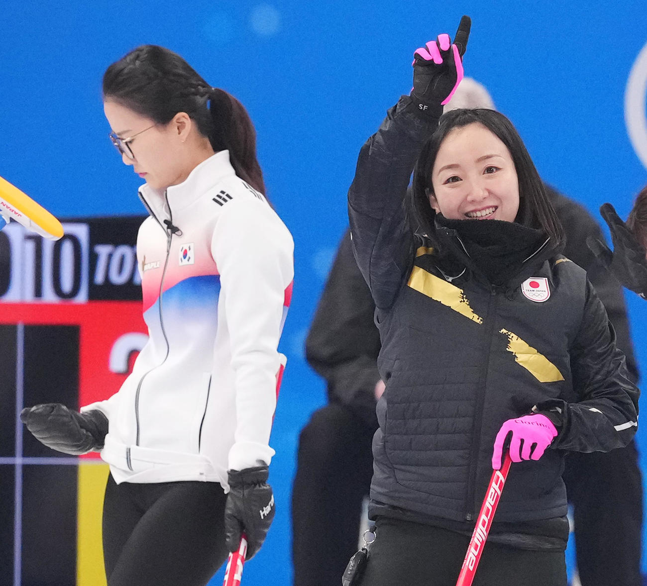 2月14日、韓国戦で相手のストーンを弾き笑顔を見せる藤沢五月（右）。左はメガネ先輩こと金ウンジョン