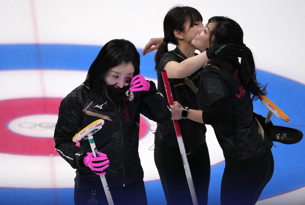 スイスに敗れた後、涙ぐむ藤沢五月（左）。右は抱き締め合う吉田知那美（右）と鈴木夕湖（AP）