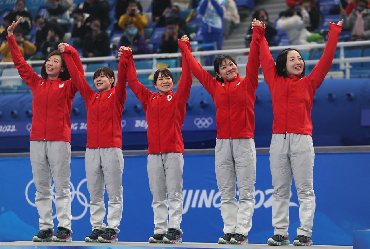 笑顔でセレモニーでの表彰台に上るロコ・ソラーレの選手たち。左から石崎琴美、吉田夕梨花、鈴木夕湖、吉田知那美、藤沢五月（ロイター）