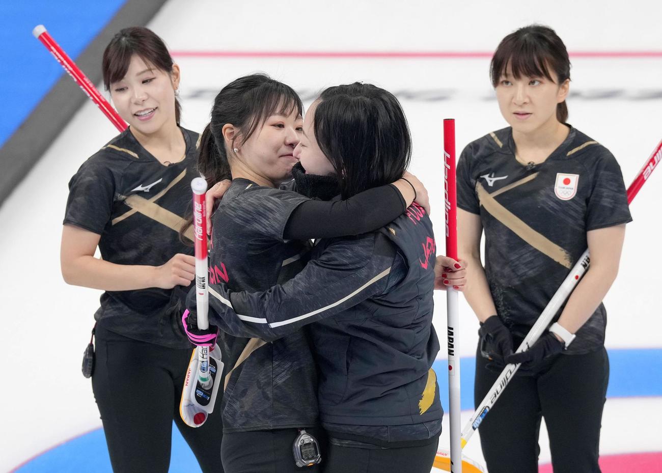 英国に敗れ、抱き合って健闘をたたえ合う吉田知（中央左）と藤沢。左端は吉田夕、右端は鈴木（共同）
