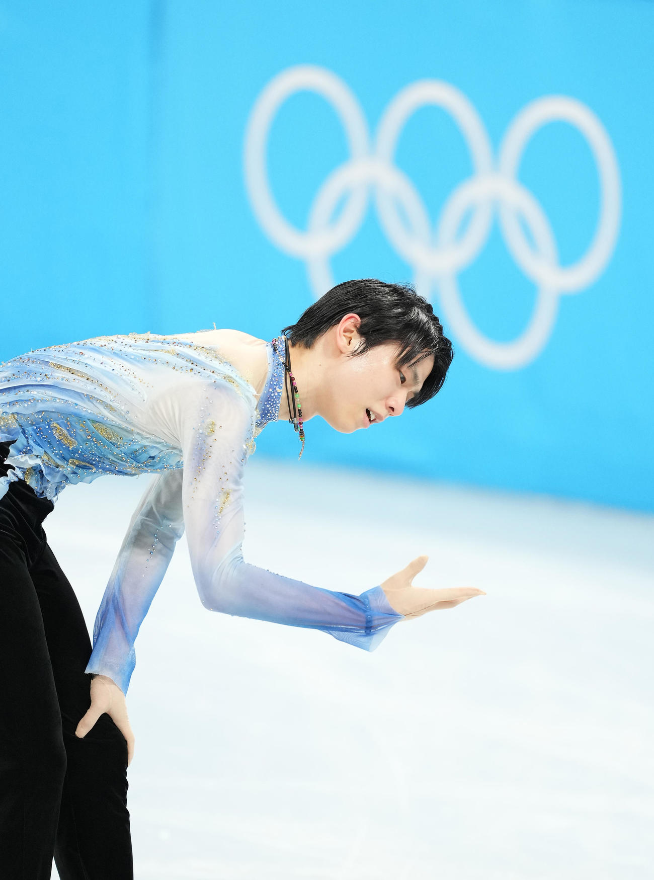 男子SPでジャンプを失敗したポイントの氷を触れ、悔しそうな表情を見せる羽生（撮影・菅敏）