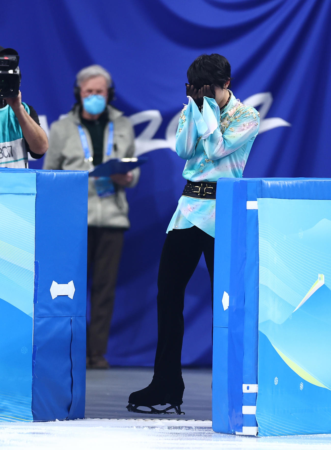 男子フリーの演技を終えリンクを引き揚げる際に手につけた氷を顔にあてる羽生（撮影・垰建太）