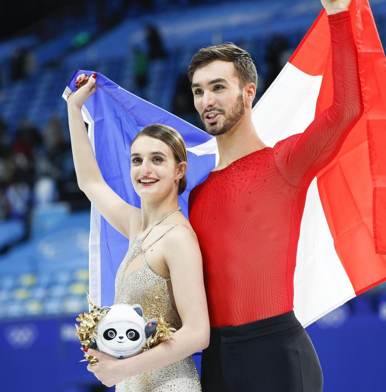 アイスダンスで優勝し、フランス国旗を広げるガブリエラ・パパダキス（左）、ギヨーム・シゼロン組（共同）