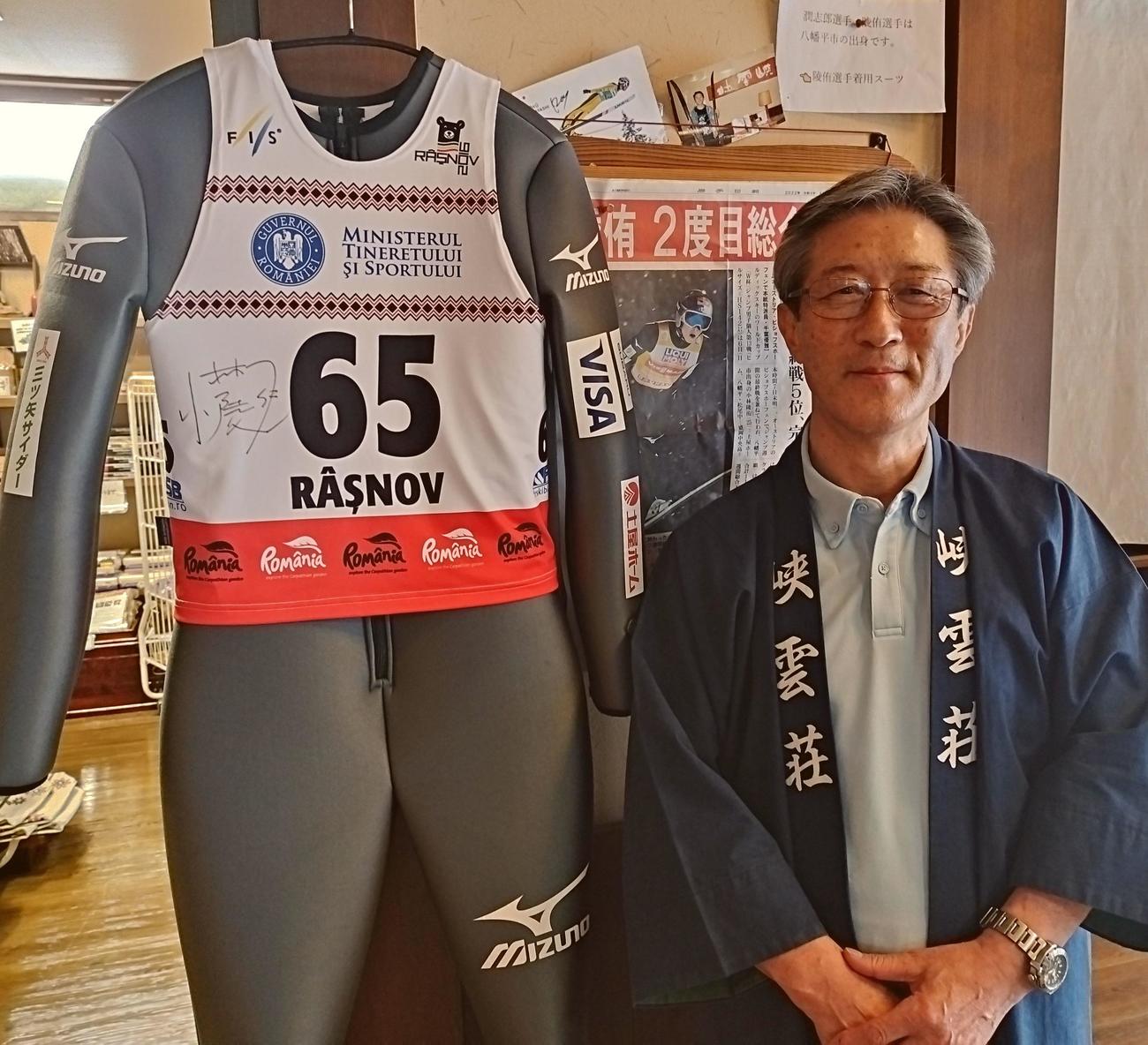 小林陵からプレゼントされたジャンプ用スーツと高橋社長（峡雲荘提供）