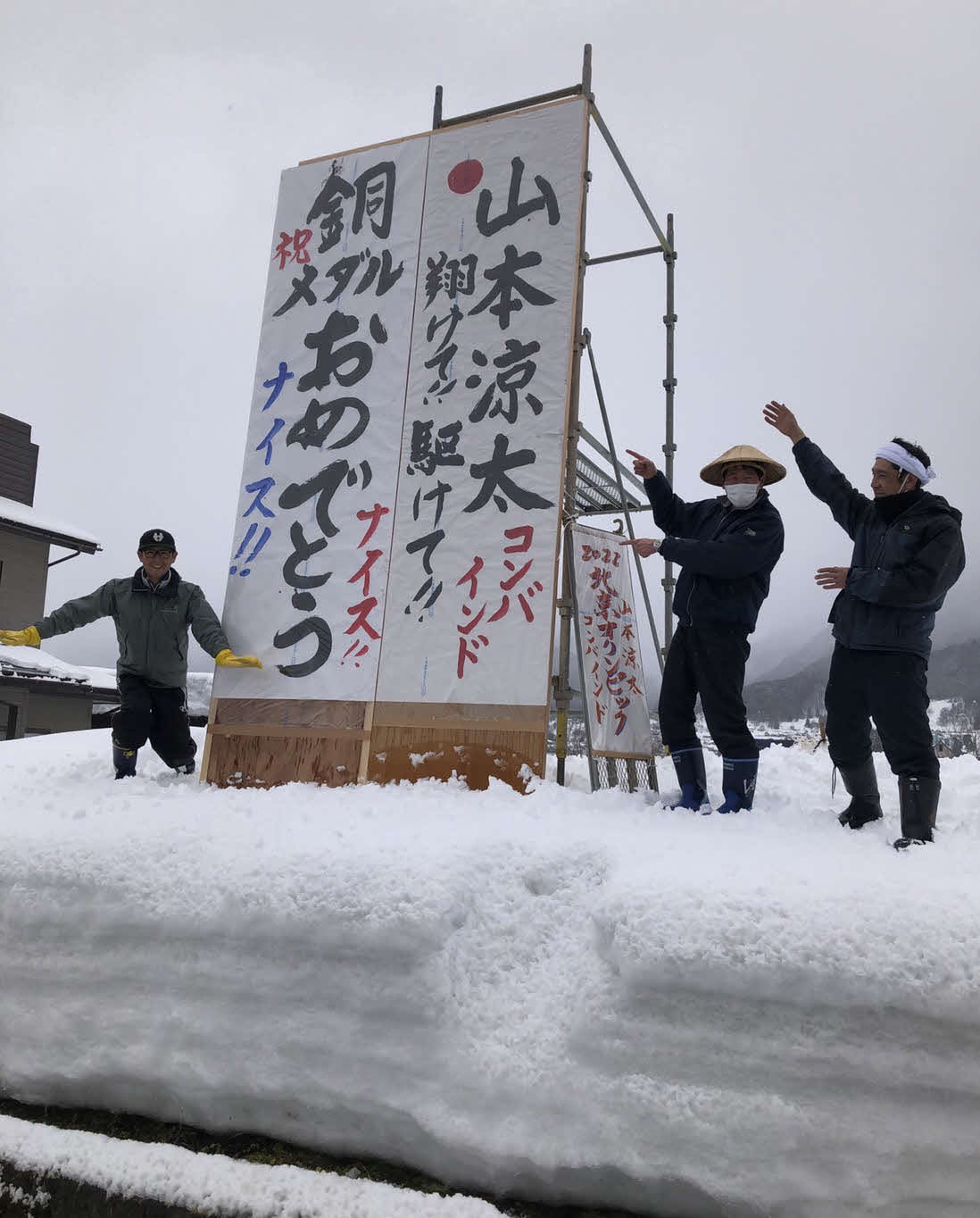木島平村の大町地区有志が18日正午すぎに雪上に立てた山本涼太の銅メダル獲得を祝福する看板（湯本大光さん提供）