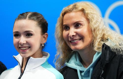 フィギュアスケート団体、女子SP後にエテリ・トゥトベリゼ・コーチとともに笑顔を見せるワリエワ(ロイター)