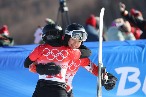 スノーボード女子パラレル大回転決勝トーナメント1回戦で途中棄権し、対戦相手のコトニク(手前)と抱き合う三木(撮影・パオロ ヌッチ)